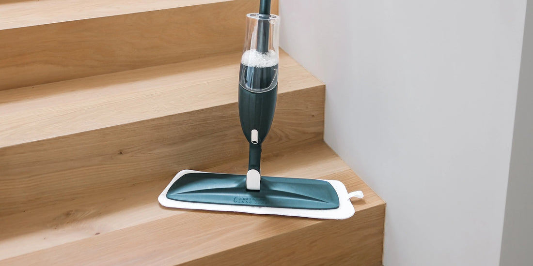 Spray mop with refillable bottle gliding across clean hardwood floor, leaving no puddles or streaks behind