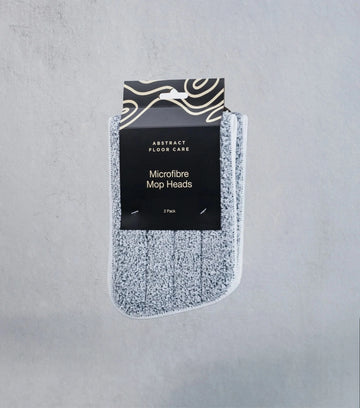 Pack of microfiber mop heads with packaging on a gray background