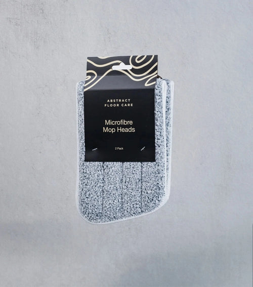 Pack of microfiber mop heads with packaging on a gray background