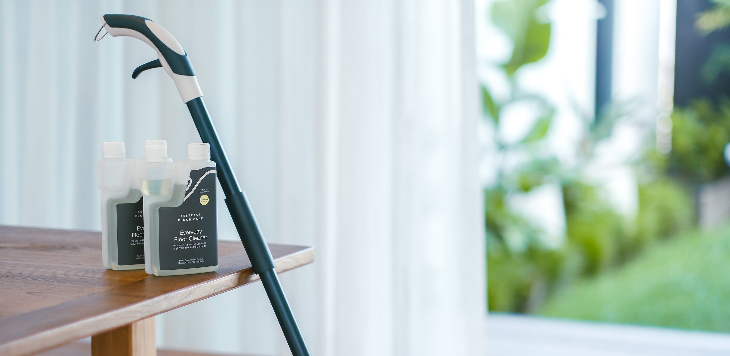 Cleaning products on a wooden table with a blurred outdoor background