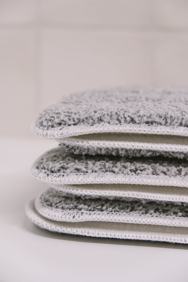 Stack of gray and white textured cloths on a light background