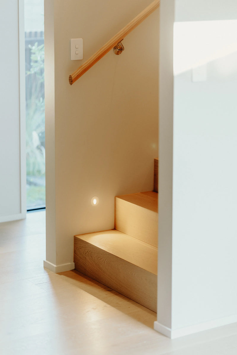 Staircase with wooden handrail in a well-lit room