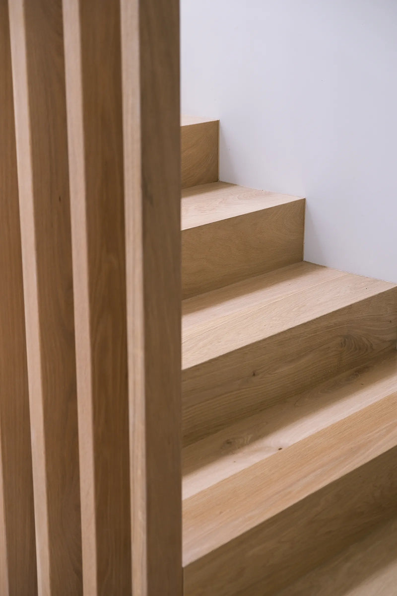 Wooden staircase with a plain white wall background