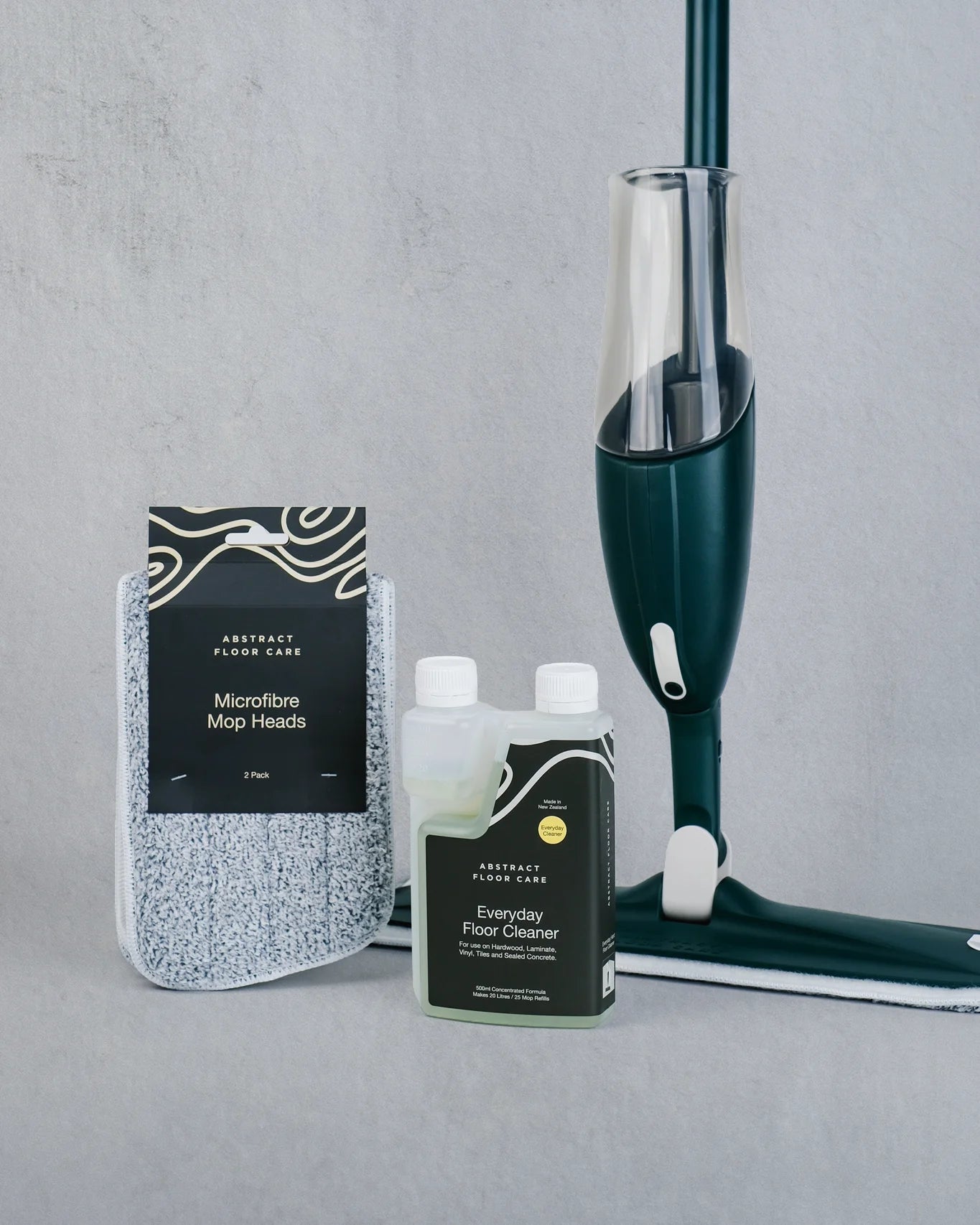 Floor cleaning products including a bottle of cleaner, microfibre mop heads, and a green mop on a gray background.